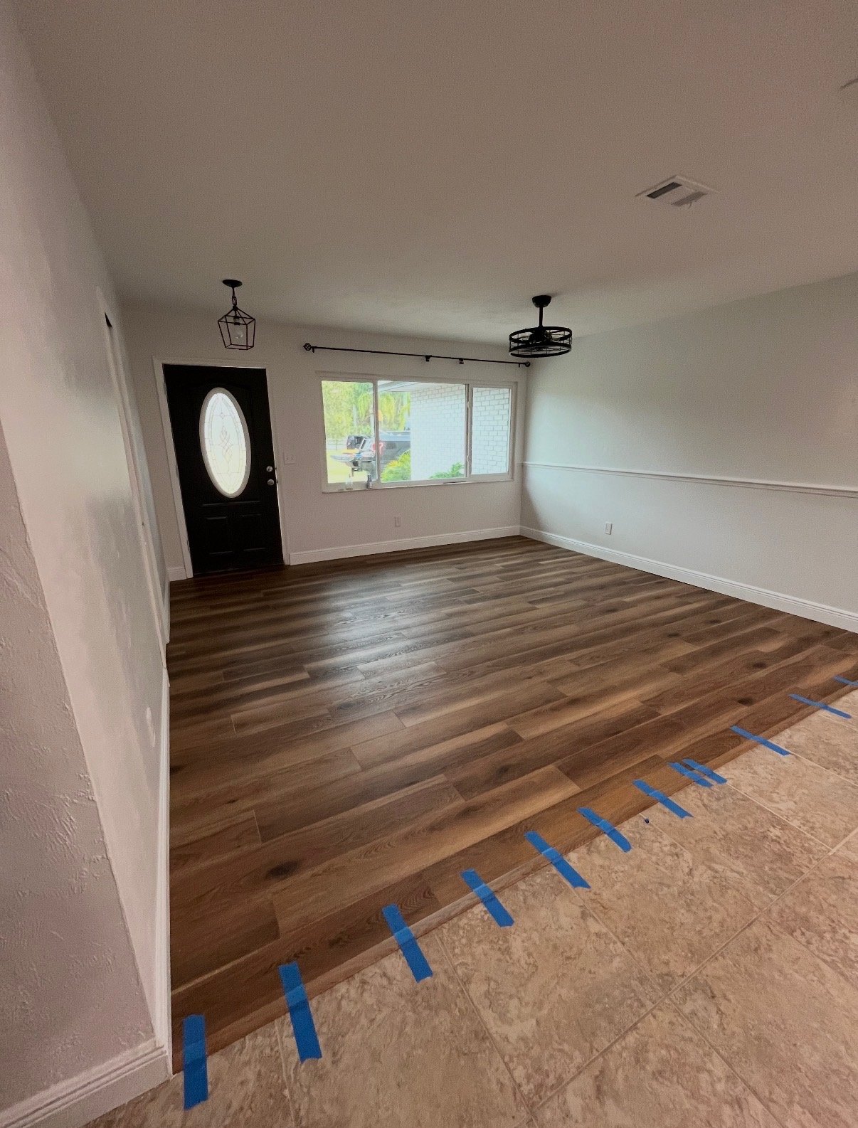 New wood-look flooring meeting existing tile at a clean transition